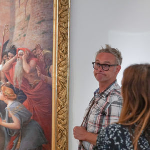 Sébastian Lazennec devant un tableau de la visite sur mesure au pied du mur